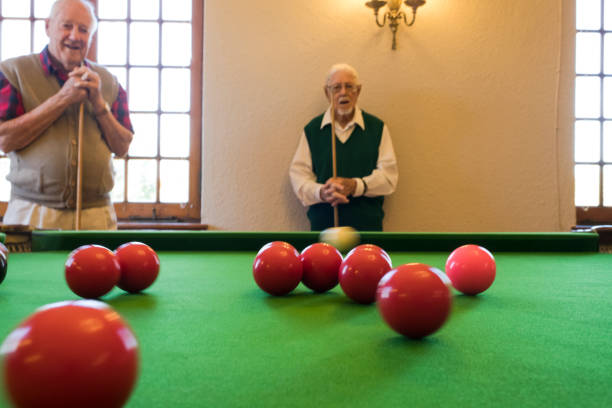 istock Motion blur snooker ball focus foreground as senior men watch 991954706
