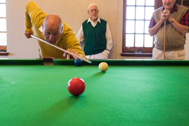 istock Front view of man using cue stick aiming at snooker ball lining up his shot 991955646