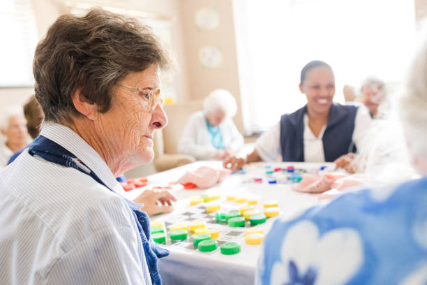 istock Senior woman profile view playing bingo in nursing home 991964876