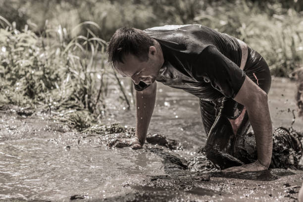 istock Individual man having sporty fun at a public mud run obstacle course 991966230