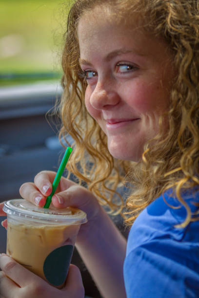 istock Pretty Young Woman Drinking an Iced Coffee 991972424
