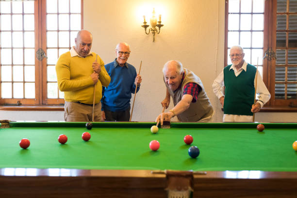 istock Active senior man hard at concentration as he takes a shot at snooker 991978274