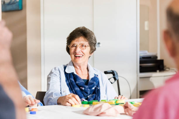 Candid portrait senior woman laughing playing bingo Candid portrait senior woman laughing playing bingo free bingo stock pictures, royalty-free photos & images