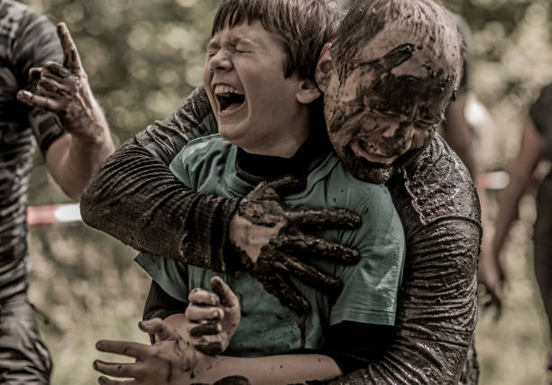 istock Father and son having sporty fun at a public mud run obstacle course 991978672