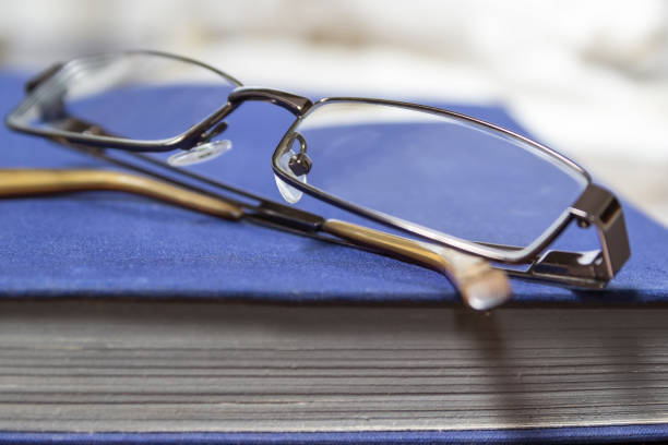 livre bleu et les verres. lunettes de soleil sur le livre. - book book cover healthcare and medicine medical exam photos et images de collection