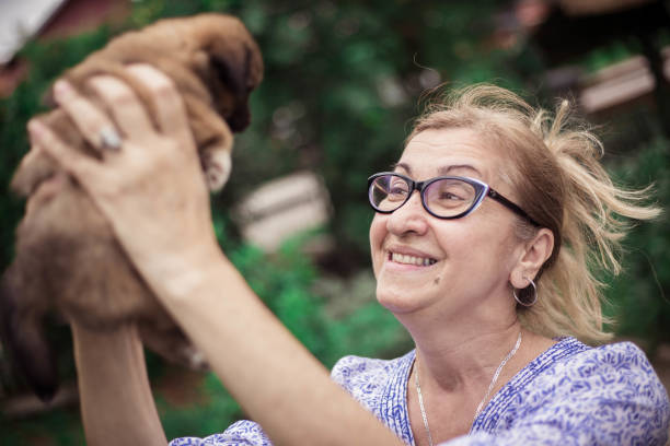 istock female senior is holding puppy 991988820