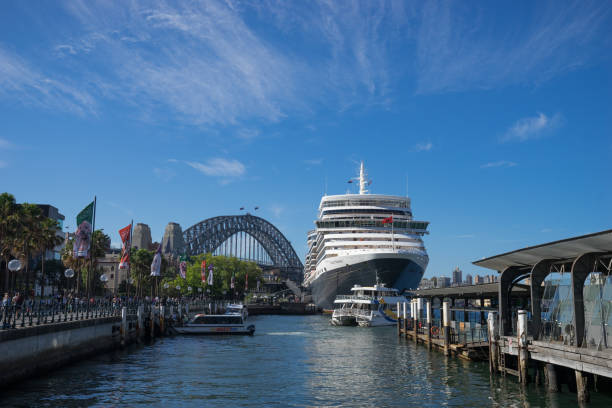 die queen elizabeth kreuzfahrtschiff, die weltweit bekannteste kreuzfahrt schiff angedockt in circular quay mit der harbour bridge und blauen himmel im hintergrund, australien: 28/02/18 - sydney harbor australia financial district cruise ship stock-fotos und bilder