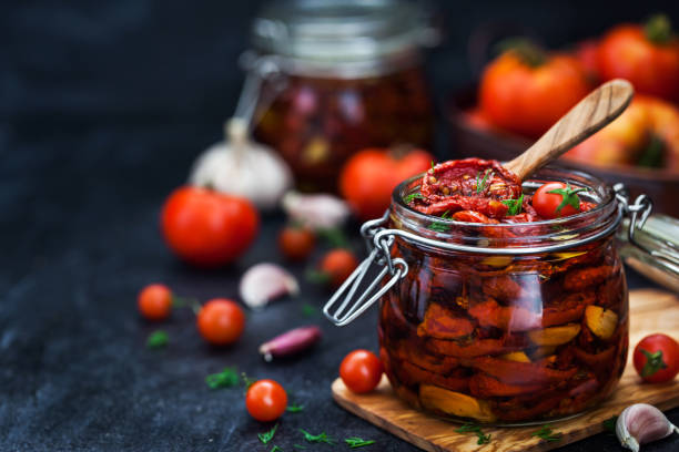 istock Sun dried tomatoes with garlic and olive oil in a jar 991994148