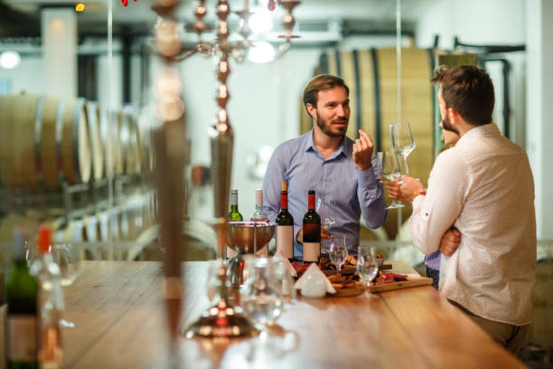 Wine tourism and degustation Sommelier presenting wines to heterosexual couple during their luxury travel to the Zvonko Bogdan winery. taste test stock pictures, royalty-free photos & images