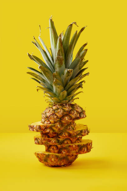istock close up view of cut pineapple exotic fruit on yellow background 991997478