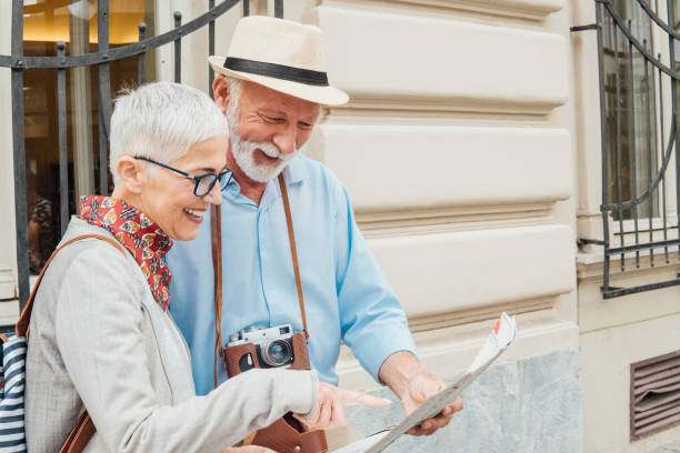 istock Senior couple of tourists using the map 991997490