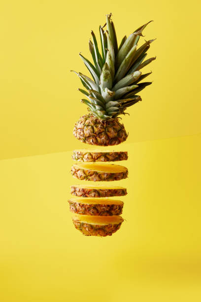 istock close up view of cut pineapple exotic fruit on yellow background 991997548