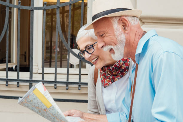 istock Smiling couple of tourists reading the map 991997628
