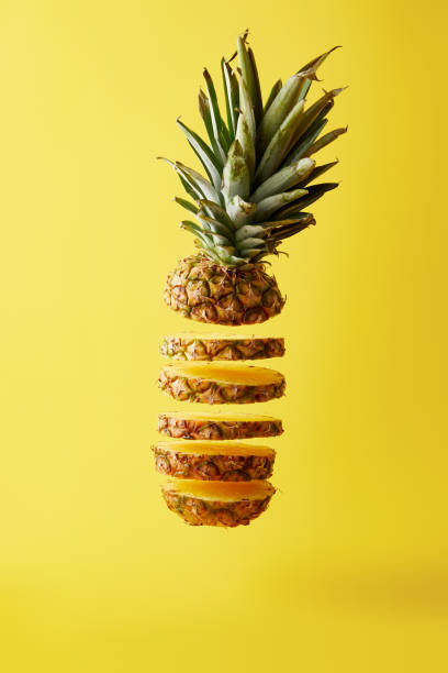 close up view of cut ripe pineapple exotic fruit isolated on yellow