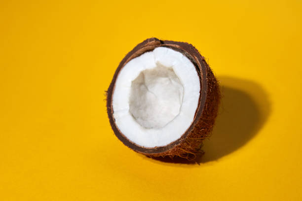 istock Half of a coconut isolated on a yellow background 992002290