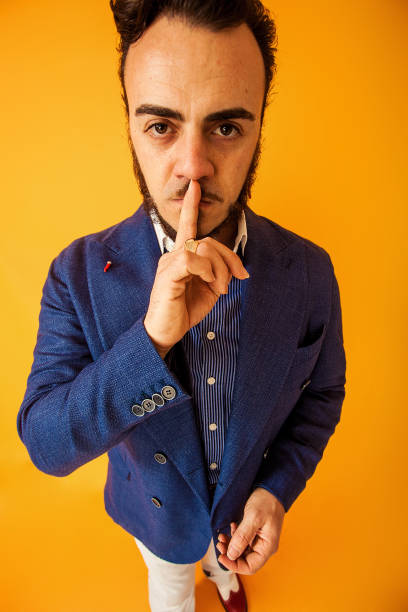istock Funny portrait of man with finger on lips, silence gesture 992003706