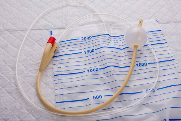 Nurse inflates urinary catheter bulb with leg drainage bag on sterile field. Nurse inflates urinary catheter bulb with leg drainage bag on sterile field catheter photos stock pictures, royalty-free photos & images