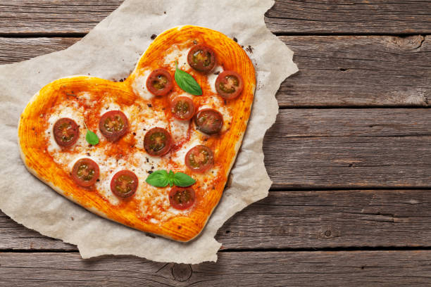 istock Heart shaped pizza with tomatoes and mozzarella 992007896