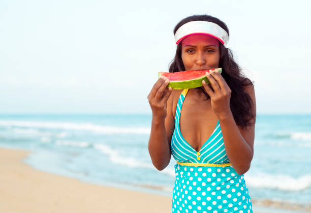 istock Woman eating watermelon at the beach. 992009056