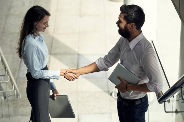 istock Cheerful coworking man and woman shaking hands 992017456