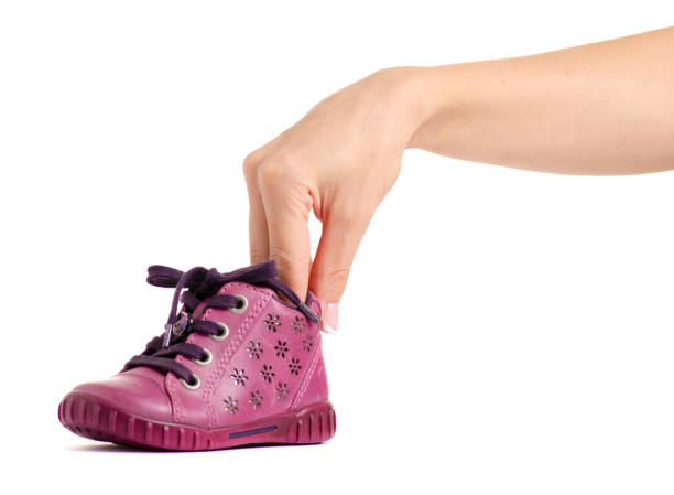 Adorable little girl helping her sister put on her shoes, showcasing a heartwarming moment of sibling bonding and childhood friendship
