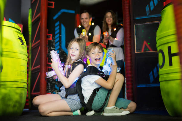istock Kids sitting back to back with laser guns 992025168