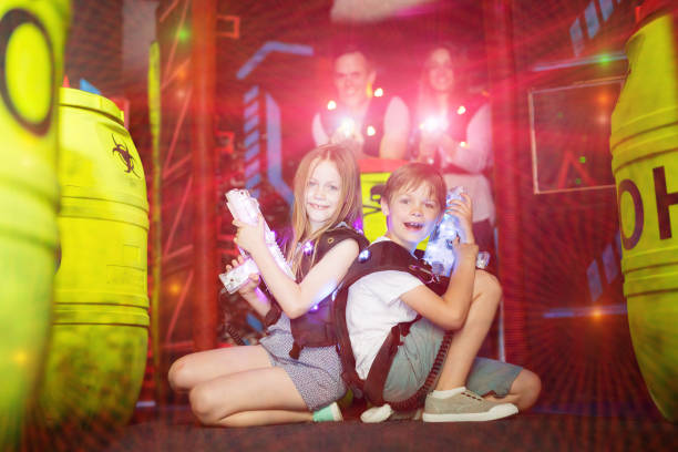 istock Kids sitting back to back with laser guns in beams 992025178