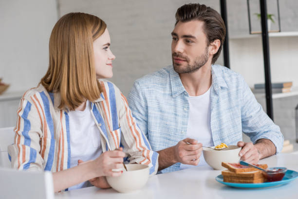 istock stylish couple sitting at table and having breakfast in kitchen 992027734