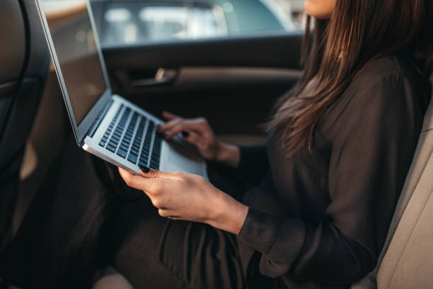 istock Woman checking e-mail on back seat of the car 992028342