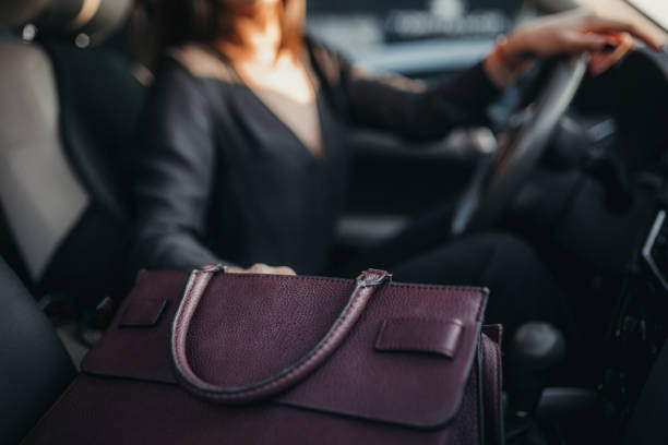 distracted driver by a purse - woman reaching into handbag imagens e fotografias de stock