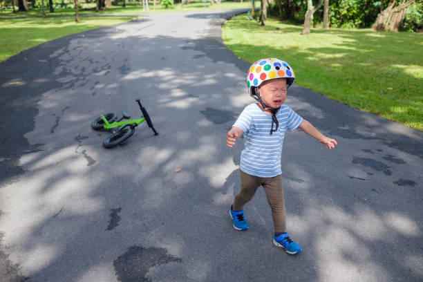 stress maux mignon triste malheureux petit asiatique 2 ans bambin bébé garçon enfant pleurant après avoir chuté de son premier vélo - 2 3 years photos et images de collection