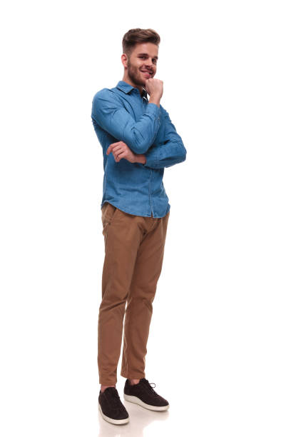 istock smiling young casual man standing and thinking 992033648