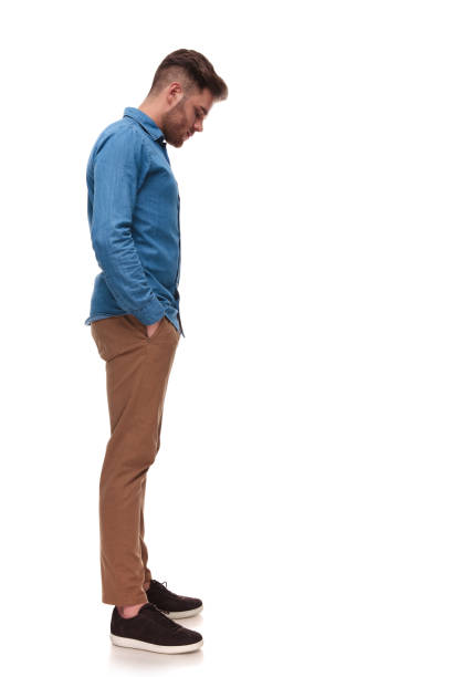 istock young casual man waiting in line looks down at something 992033806