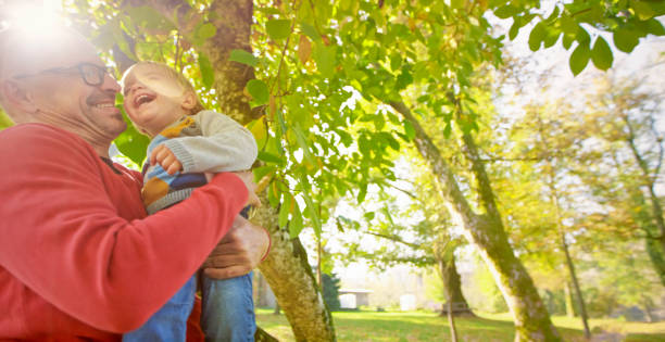 istock Father and son smiling in park 992034570