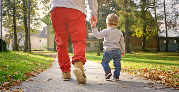istock Father and son walking in park 992034602
