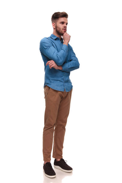 istock pensive casual man with beard looks to side while standing 992039190