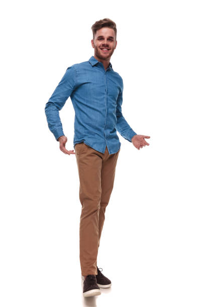 istock happy casual man wearing a blue shirt standing and presenting 992041440