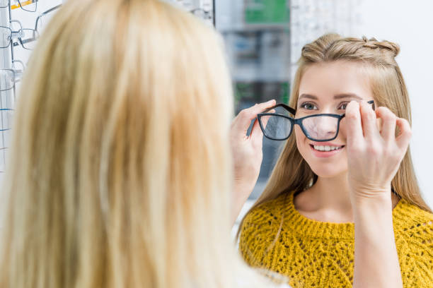 istock oculist helping client to choose eyeglasses in optics 992042592