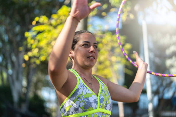 istock Woman training rotates hula hoop 992047594