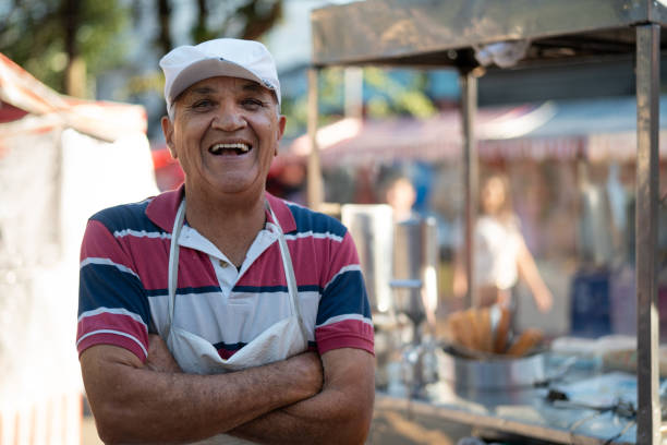 oudere man verkopen churros op straat portret - straatverkoper stockfoto's en -beelden