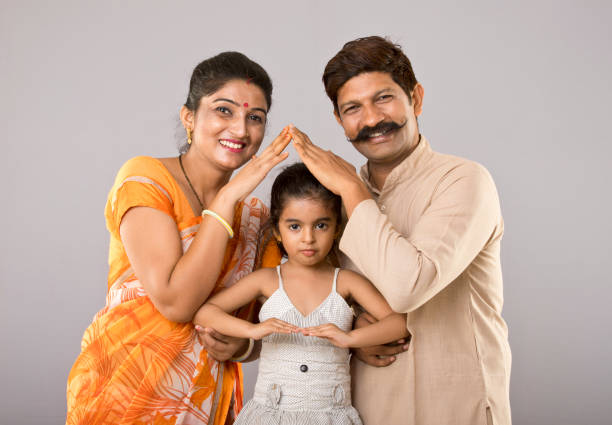 Indian family forming house symbol Portrait of parents with daughter forming house symbol happy indian young family couple stock pictures, royalty-free photos & images