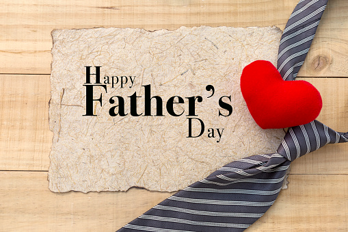 Father's day card concept, red heart and necktie with happy father' day card on wood background
