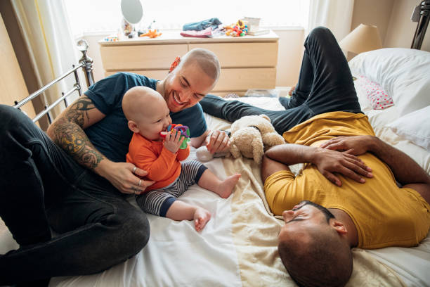 coppia gay che guarda il loro figlio giocare - tattoo father family son foto e immagini stock