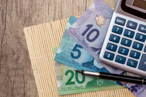 istock Canadian dollars on wooden desk, macro . 992078688