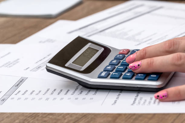 istock Woman counting her budget, hands with calculator 992078960