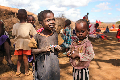 Unknown Masai village near Amboselli park, Kenya - April 02, 2015: Poor dirty Masai children with faces and mouth covered with flies.