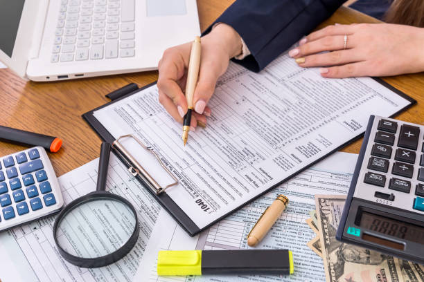 istock Female hands with 1040 form, preparing to fill 992079500
