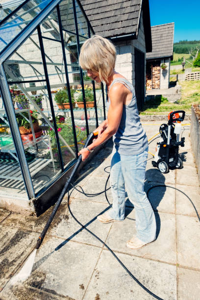 istock Woman using pressure washer in garden 992079800