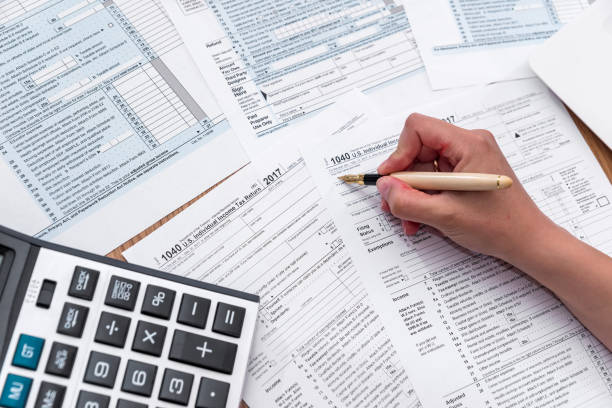 istock 1040 form with female hand, pen and calculator 992080396