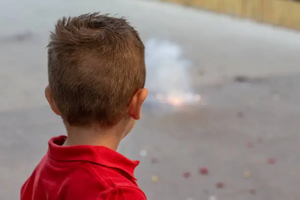 Photo of Boy looking a firecracker about to explode